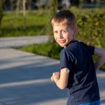 Child wearing a continuous glucose monitor outdoors at summer camp